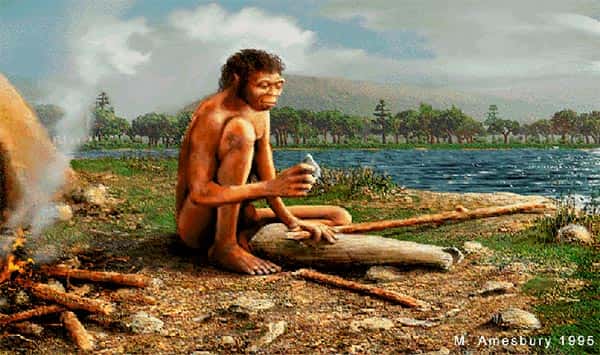 Homem primitivo fazendo ferramenta com pedra