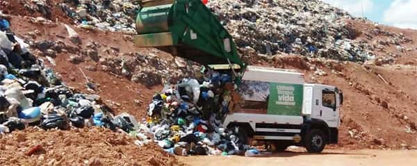 Caminhão de coleta de lixo despejando lixo no aterro sanitario