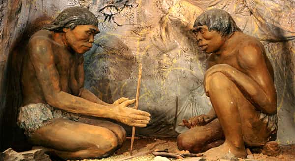 Homens primitivos tentando fazer fogo